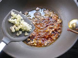 Steamed Tofu with Minced Pork step 10: Stir-fry until red oil is released, then add ginger and garlic mince and stir-fr
