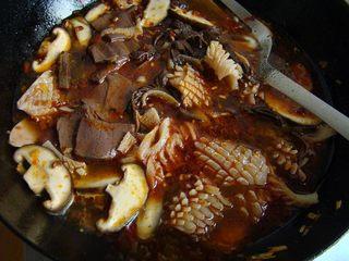 Mao Xue Wang (Sichuan Spicy Duck Blood Hot Pot) step 9: Add the mushrooms first. Season with Shaoxing wine, sugar, salt, and chicken bou