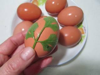 Five-Spice Botanical Tea Eggs step 3: Place decorative leaves against the surface of each eggshell.