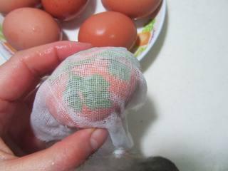 Five-Spice Botanical Tea Eggs step 4: Wrap each egg tightly with damp cheesecloth, securing the leaves in place.