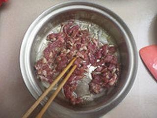Bitter Gourd and Pork Stir-Fry step 5: Heat oil in a wok and stir-fry the marinated pork until cooked.