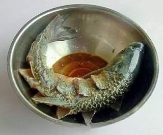 Sweet and Sour Carp Recipe step 2: Score the fish with decorative cuts and marinate with salt, soy sauce, and peppe