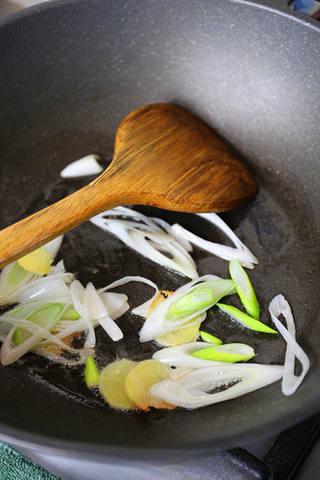 Braised Lamb Leg with Carrots step 2: Heat oil in a heavy pot. Add sliced scallion and ginger and sauté until fragrant
