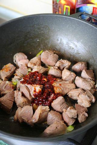 Braised Lamb Leg with Carrots step 4: Add the doubanjiang and stir-fry until the oil turns red and fragrant.