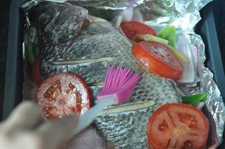 Baked Tilapia with Vegetables step 7: Arrange the tomato slices over the fish and brush a generous layer of marinade o