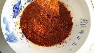 Homemade Spicy Chili Oil step 4: Divide the chili mixture into two portions. Pour a ladle of hot oil over the fir