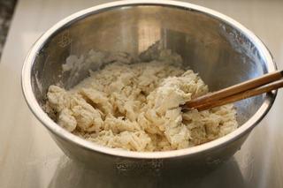 Steamed Milk Bread Rolls step 3: Gradually add the cream and water while stirring until shaggy dough forms.