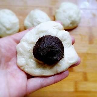 Sweet Red Bean Milk Bread Rolls Recipe step 5: Flatten each portion, place red bean paste in the center, and seal tightly.