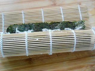 Grilled Eel Sushi Rolls step 4: Starting from the edge closest to you, roll the nori tightly around the filling.