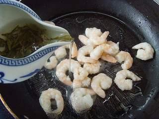 Shrimp with Dragon Well Tea Recipe step 6: Add the brewed tea leaves and tea liquor to the wok.