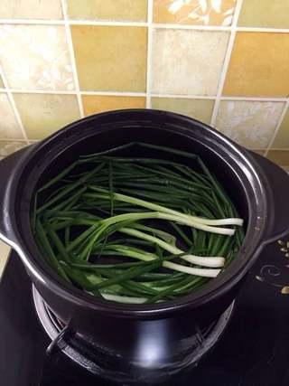Clay Pot Braised Pork Belly Recipe step 4: Arrange the scallions and ginger slices across the bottom of the pot.