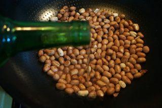 Peanut Cucumber Salad Recipe step 3: Add a few drops of Shaoxing wine. Once the peanut skins begin to crack, remove f