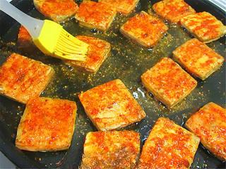 Pan-Fried Stinky Tofu step 6: Brush each piece with sweet bean sauce, sprinkle with chili powder, and continue