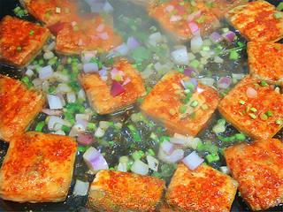 Pan-Fried Stinky Tofu step 7: When the tofu develops a lightly crisp crust, add the onion and toss briefly. Tr