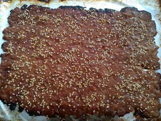 Homemade Pork Jerky step 15: When lightly browned, flip the pork sheet, brush with more honey glaze, sprinkle