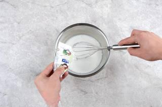Homemade Coconut Yogurt step 3: When the milk cools to about 65°C (150°F), add the sugar and coconut milk. Stir 