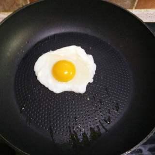 Korean Stone Pot Bibimbap step 7: Heat a small amount of oil in a skillet and fry the egg until the whites are set