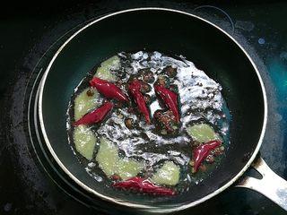 Spicy Black Fungus Salad with Peanuts step 5: Heat a little oil over low heat. Add the Sichuan peppercorns, dried chilies, and