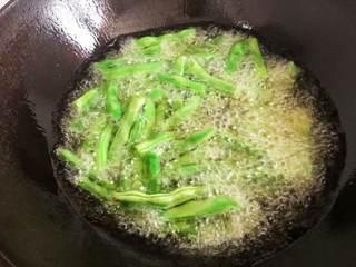 Stir-Fried String Beans with Minced Pork step 2: Heat enough oil in a wok and add the string beans.