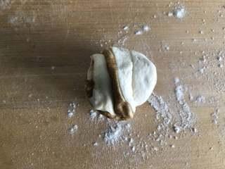 Sesame Twisted Steamed Rolls step 8: Stretch the ends slightly, twist them together, pinch firmly, and tuck the seam 