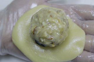 Five-Nut Mooncakes step 9: Flatten a dough ball and place a filling ball in the center.