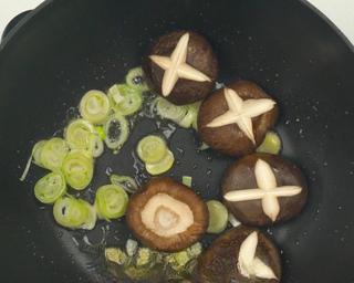 Braised Lion's Head Meatballs step 8: In the same pan, sauté ginger, green onion, and mushrooms until fragrant.