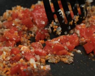 Beef and Tomato Pasta step 9: Stir in the tomatoes, carrot, parsley, tomato paste, and 200 ml water. Mix well.