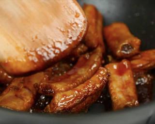 Braised Pork Ribs step 5: When the sugar turns amber and develops fine bubbles, add the ribs and stir-fry