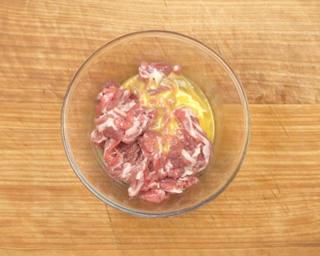 Scallion Lamb Stir-Fry step 6: Add half of the beaten egg and mix until evenly coated.