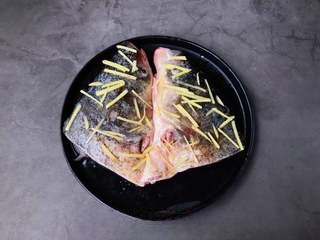 Steamed Fish Head with Chili Sauce step 2: Rub the fish head with Shaoxing wine, salt, and white pepper. Scatter shredded g
