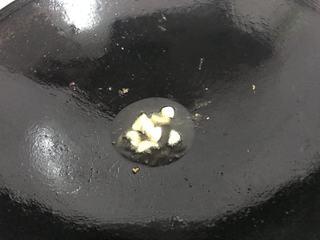 Braised Sea Bass Recipe step 5: Leave a small amount of oil in the pan. Add the ginger and garlic, then sauté un