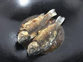 Braised Sea Bass Recipe step 7: Return the fried sea bass to the pan and spoon the sauce over the fish while it