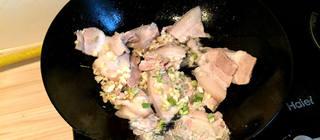 Twice-Cooked Pork with Peppers step 3: Heat a small amount of oil in a wok. Add the pork slices along with the scallion
