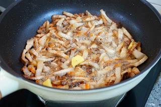 Braised Pork Belly with Mushrooms and Eggs step 10: Add ginger slices and continue stir-frying until fragrant.