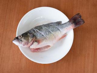 Chinese Steamed Sea Bass step 2: Rub the fish with rice wine, salt, white pepper, and ginger powder. Allow it to 