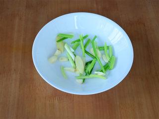 Chinese Steamed Sea Bass step 3: Arrange sliced scallions, ginger, and garlic in the bottom of a heatproof steami