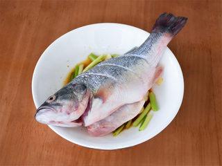 Chinese Steamed Sea Bass step 6: Lay the sea bass on top of the aromatics.