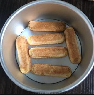 Classic Tiramisu Cake step 8: Arrange a layer of soaked ladyfingers across the bottom of a 6-inch cake pan.