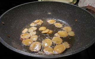 Clay Pot Basil Chicken step 4: Add the ginger slices and continue stir-frying until aromatic.