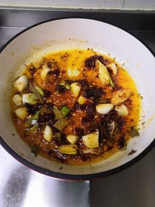 Braised Pork Trotters step 5: Cook until the chili oil turns deep red and aromatic.