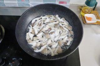 Stir-Fried Mushrooms with Cured Pork step 2: Bring a pot of water to a boil and blanch the mushrooms for 1 minute. Drain well