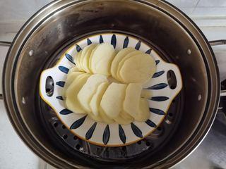 Mashed Potato Volcano with Braised Pork Sauce step 2: Slice the potato into thin rounds and steam for about 15 minutes until tender.