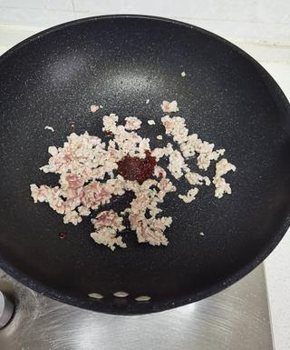 Mashed Potato Volcano with Braised Pork Sauce step 8: Add the fermented bean paste and cook until aromatic and the oil turns reddish.
