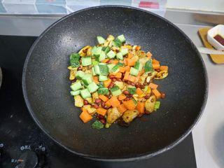 Kung Pao Chicken step 9: Return the chicken to the wok and add the carrots, cucumber, and peanuts. Stir-f