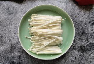 Spicy and Numbing Fish Hotpot step 1: Trim the roots from the enoki mushrooms, rinse thoroughly, and set aside.