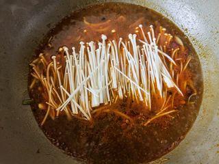 Spicy and Numbing Fish Hotpot step 12: Cook the enoki mushrooms in the broth until just tender.