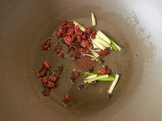Spicy and Numbing Fish Hotpot step 6: Heat oil in a pot and sauté ginger, garlic, Sichuan peppercorns, and dried red c