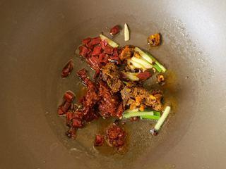 Spicy and Numbing Fish Hotpot step 7: Add Pixian doubanjiang and hot pot base, stir-frying until the oil turns red and