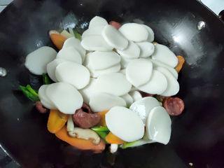 Stir-Fried Rice Cakes with Crispy Sausage and Vegetables step 7: Drain the rice cake slices thoroughly and add them to the wok. Stir-fry for 1–2