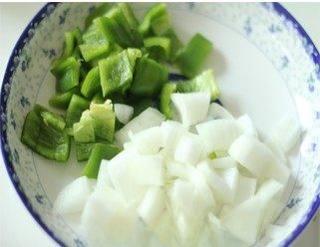 Cumin Chicken with Spicy Chili Crunch step 1: Cut the green bell peppers and onion into 1 cm cubes.